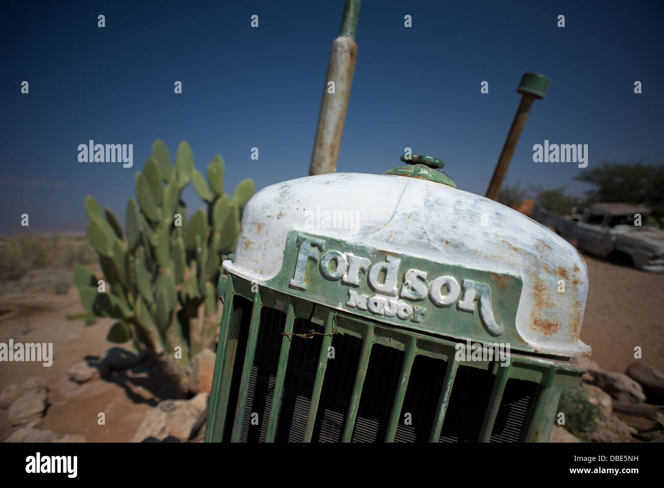 Old vehicles in desert surrounded by cactus Stock Photo