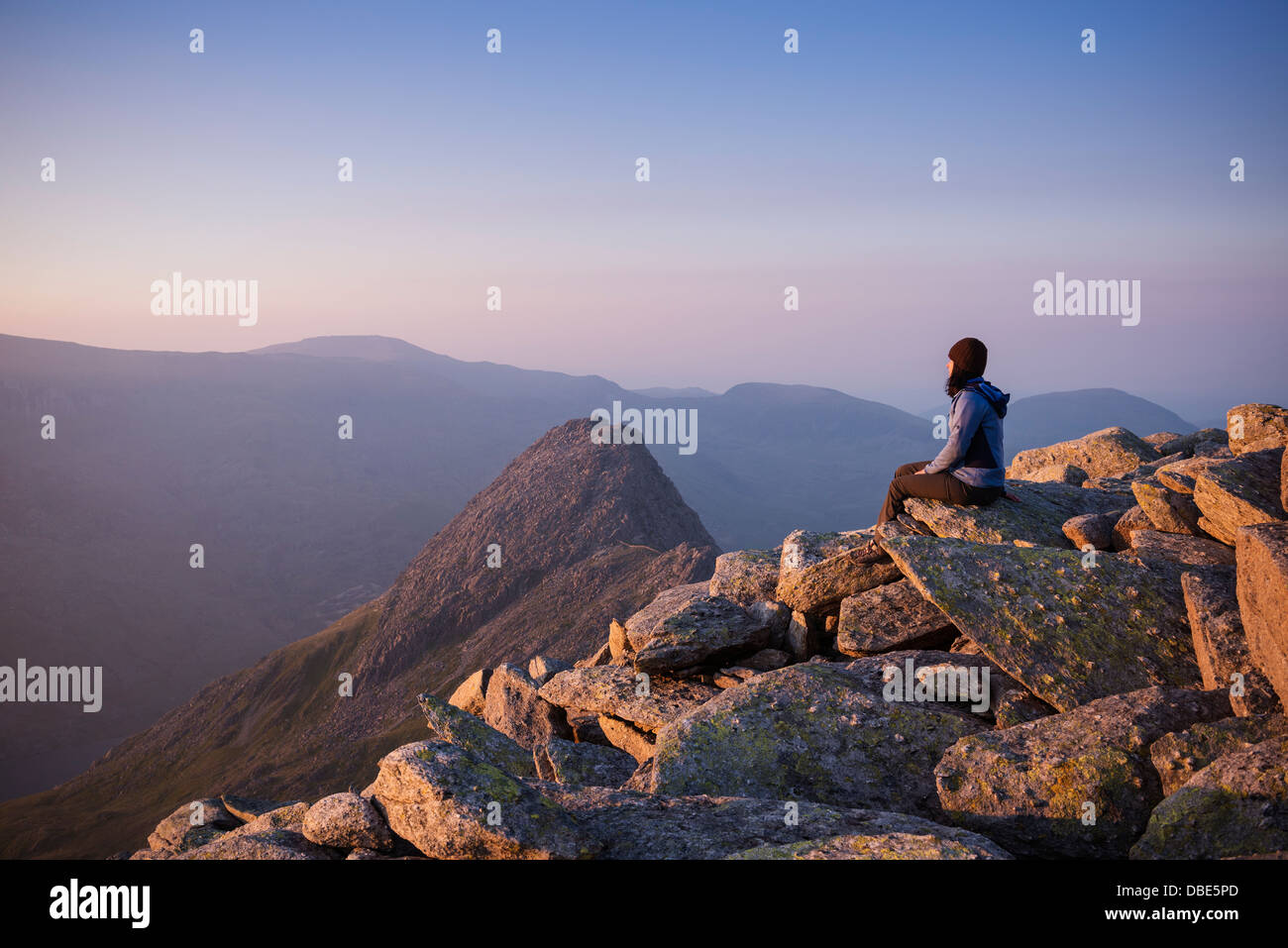 Female hiker on summit of Glyder Fach with Tryfan in background, Snowdonia national park, Wales Stock Photo