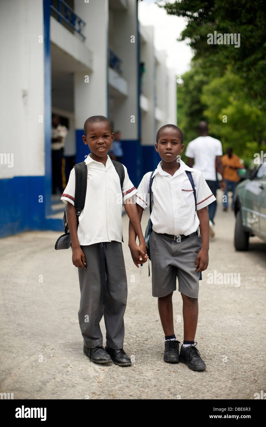 Young schoolboys hang out outside of the Petionville police station in Port au Prince, Haiti Stock Photo