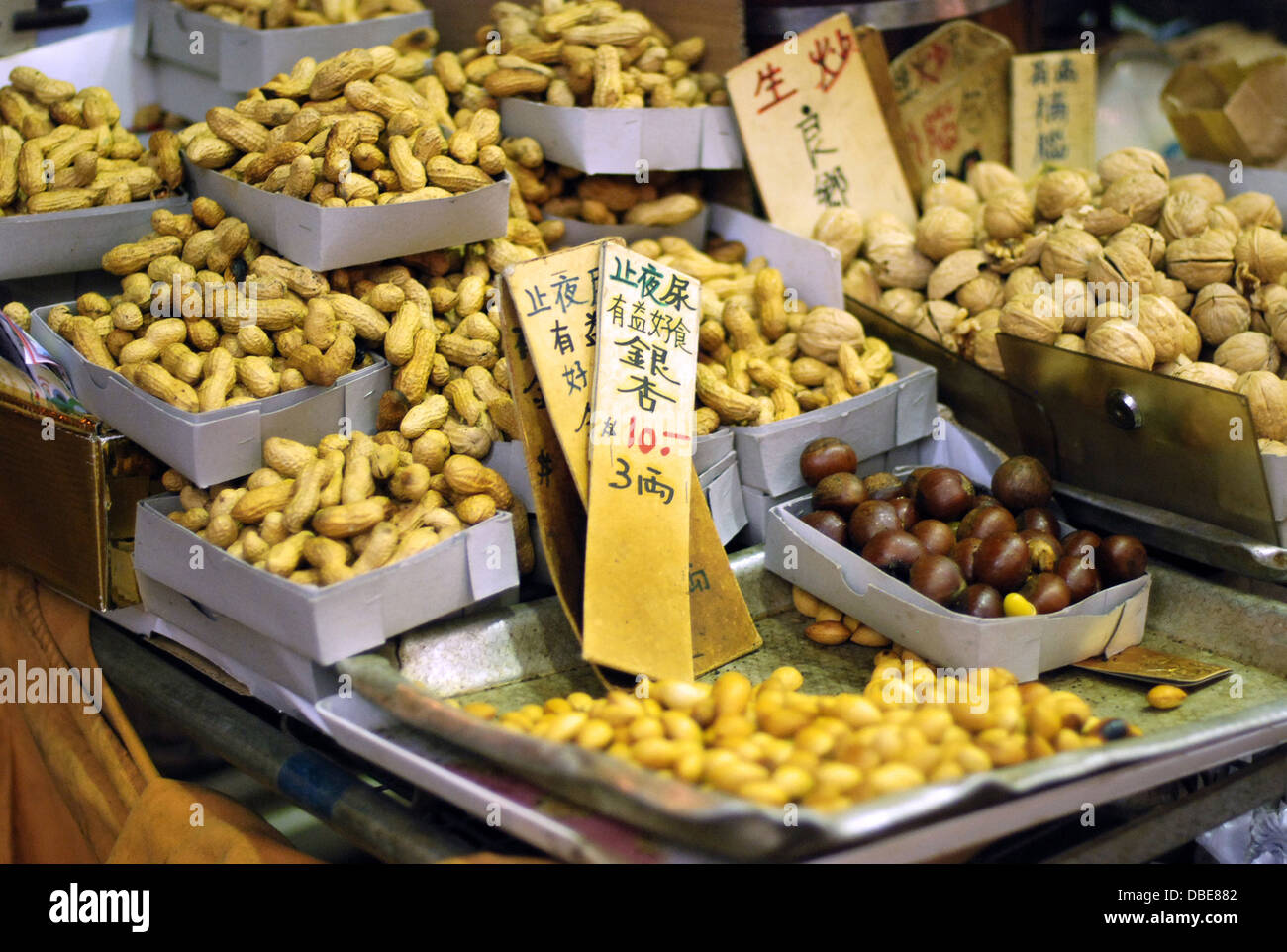 A street vendor selling fresh peanuts, walnuts, and chestnuts from a