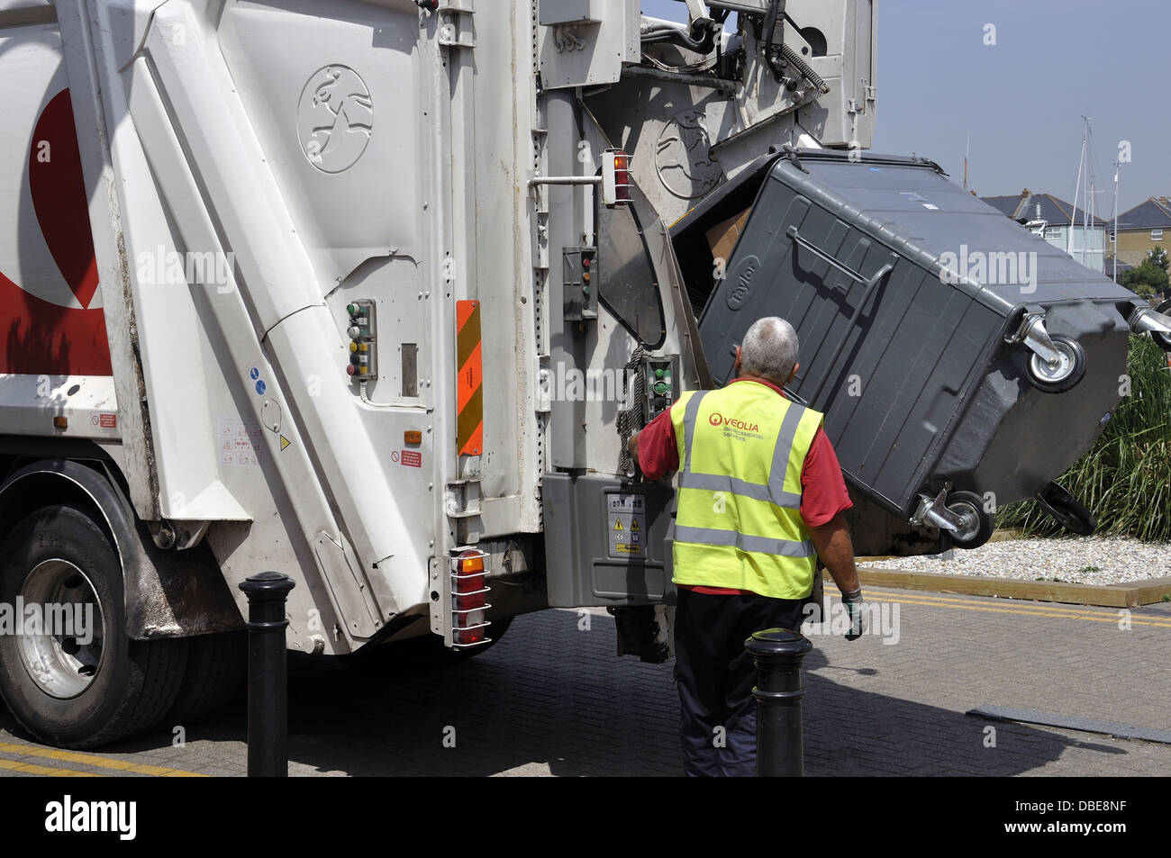 Refuse wagon with commercial bin being emptied by yellow jacketed operator Stock Photo Alamy