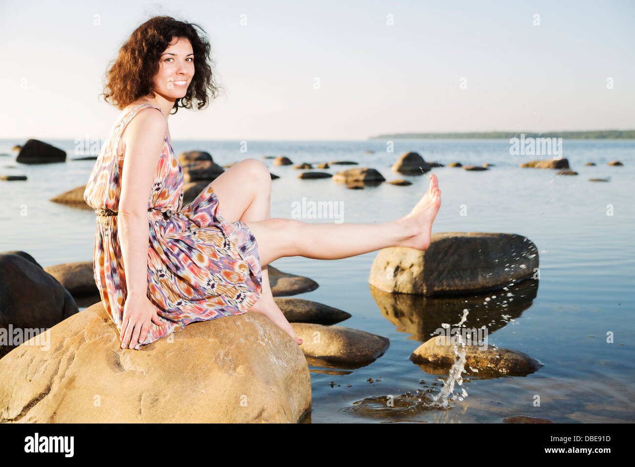 Barefoot woman squirts water drops Stock Photo