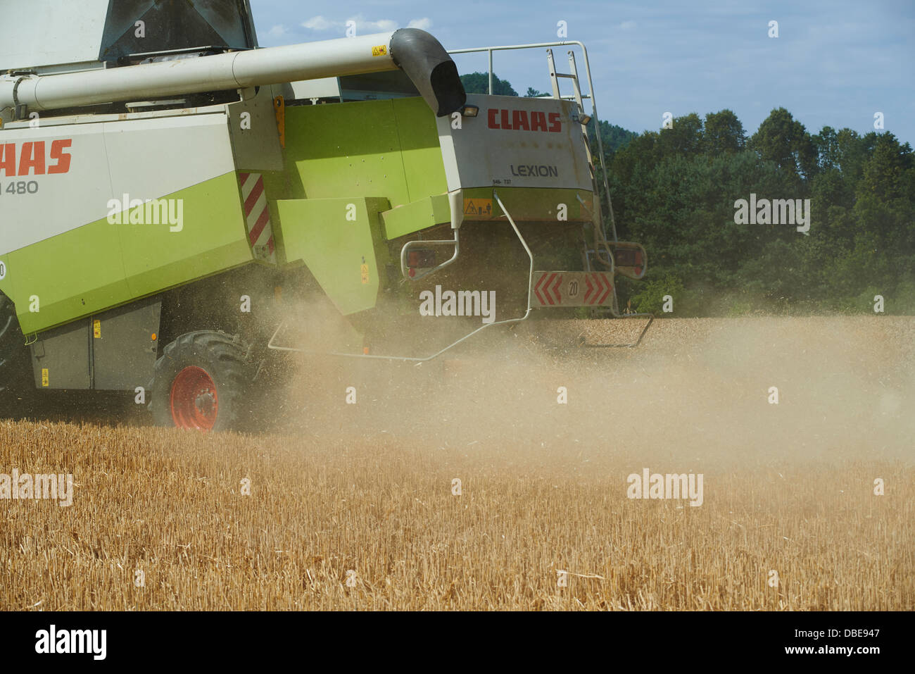 Combine harvester harvesting field of wheat. Summer Stock Photo - Alamy