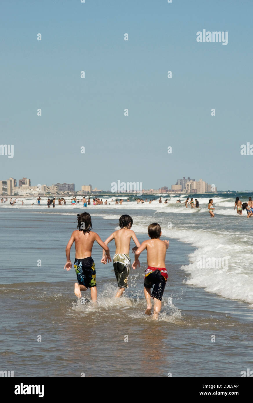 Unidentifiable boys playing in the water at Rockaway beach in New York City, USA. Stock Photo