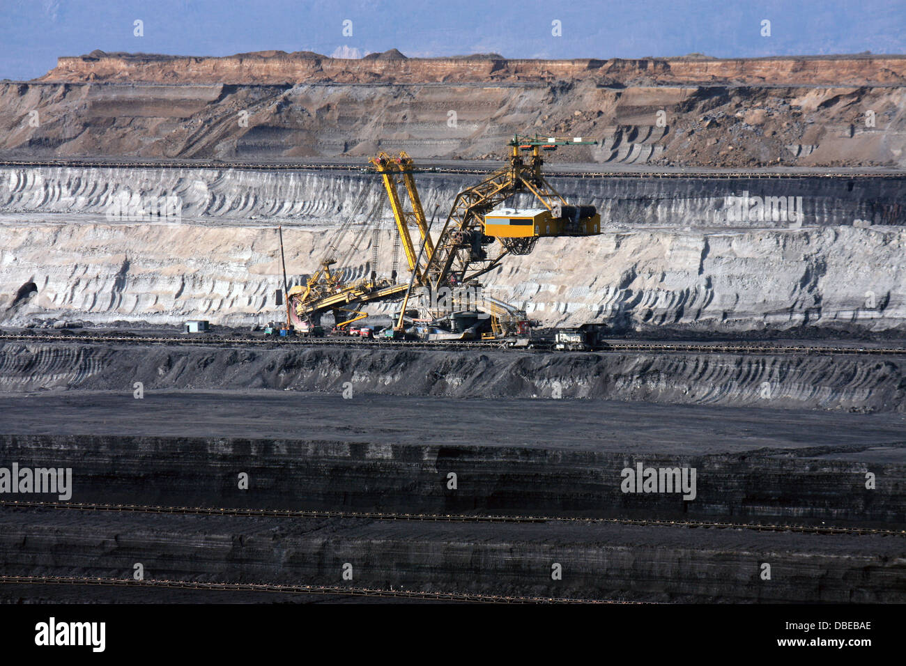 huge and deep coal mine with excavator machine in europe Stock Photo