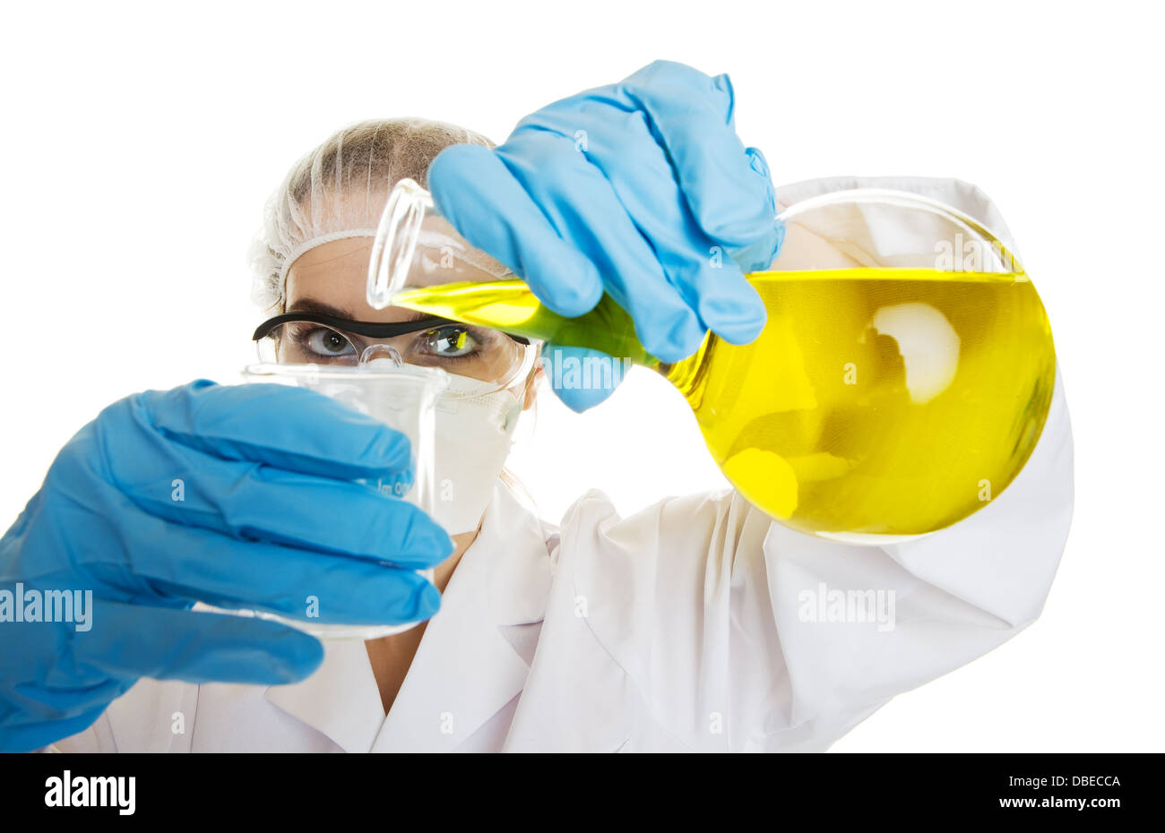 A professional lab worker pouring yellow liquid into a beaker Stock Photo