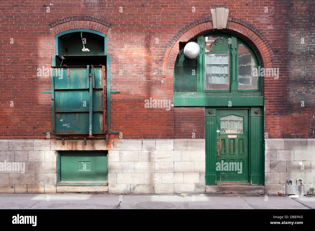 Green loading dock and entrance door, old industrial building. Stock Photo