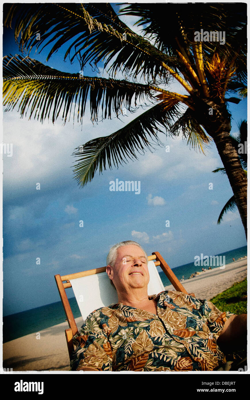 Older man relaxing on tropical beach - Smartphone Captured Stock Image