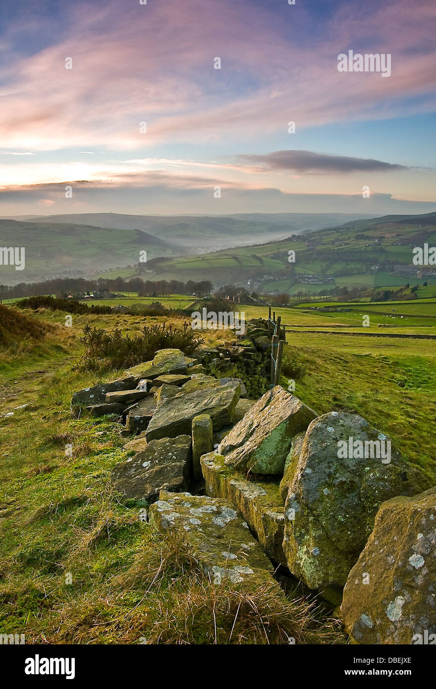 A dry stone wall leading towards a beautiful autumn sunset in the yorkshire dales Stock Photo