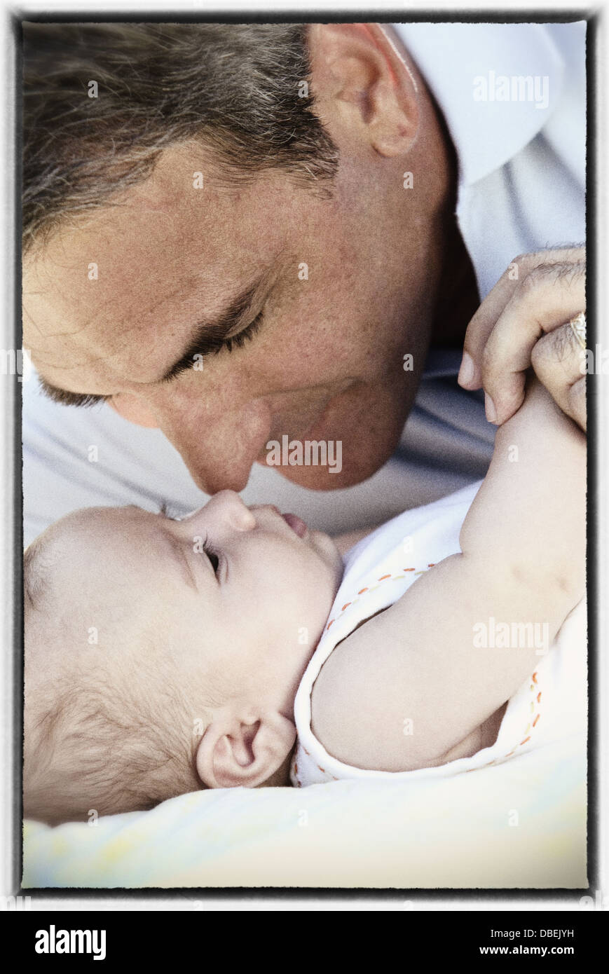 Hispanic father touching noses with baby - Smartphone Captured Stock Image