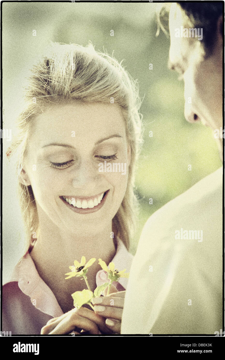 Hispanic man giving girlfriend flowers - Smartphone Captured Stock Image