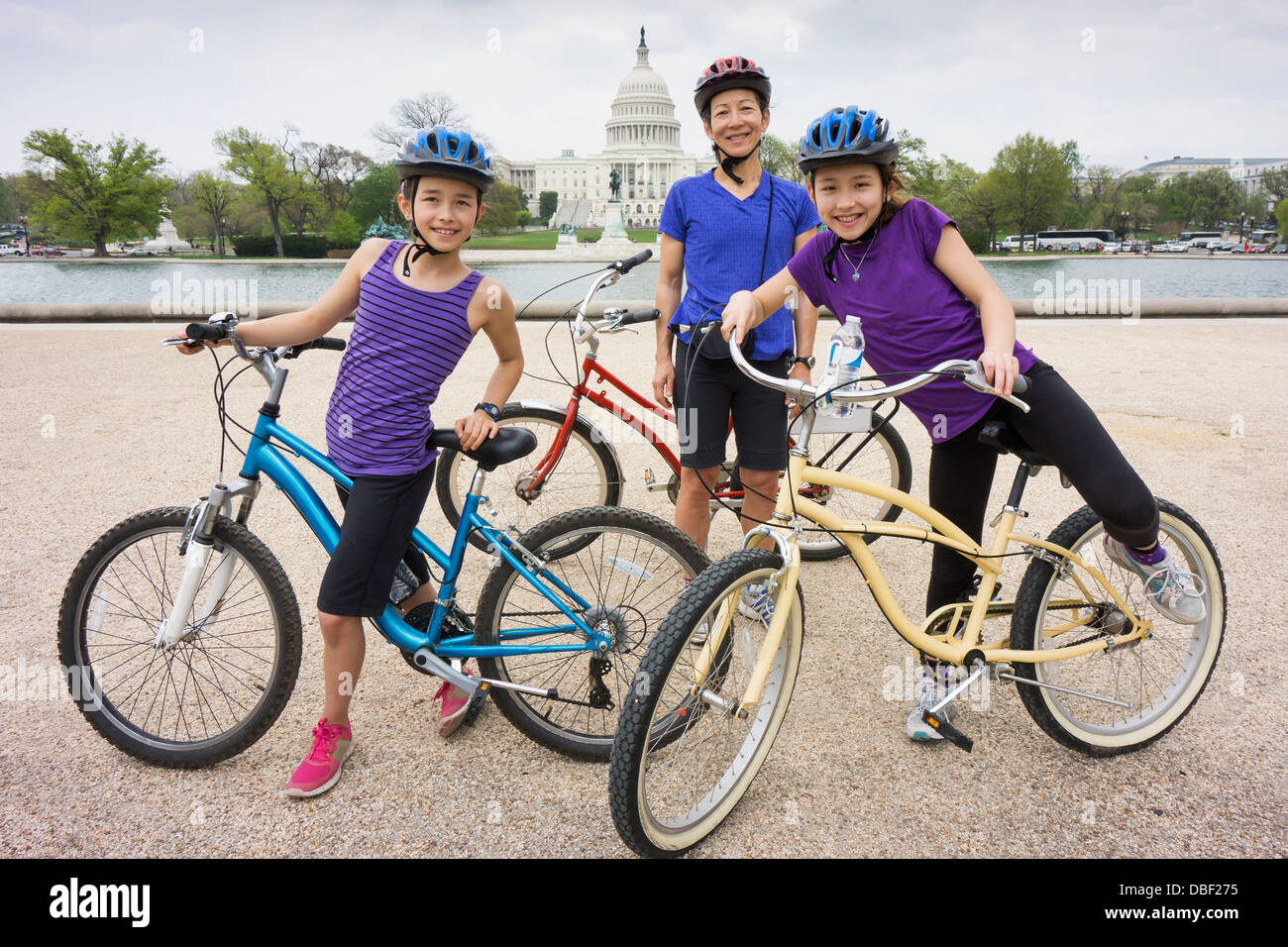 Mother and daughters riding bicycles by Capitol Building, District of Columbia, United States Stock Photo