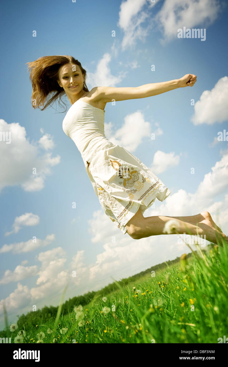 Happy Young Woman Jumping Over Blue Sky Stock Photo - Alamy