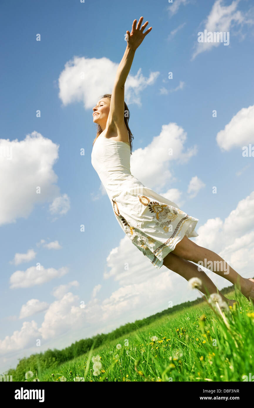 Happy Young Woman Jumping Over Blue Sky Stock Photo - Alamy