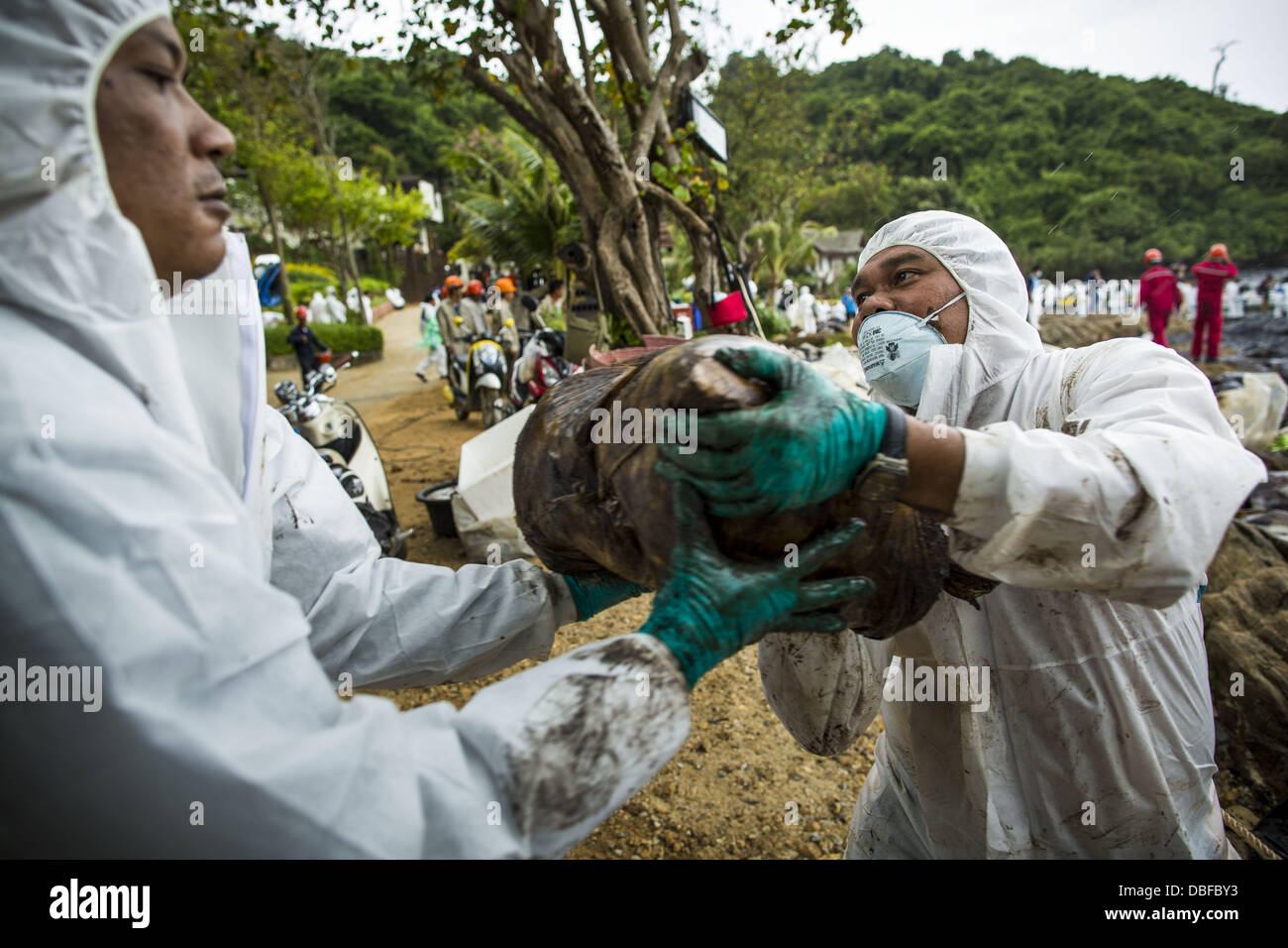 Koh Samet, Rayong, Thailand. 30th July, 2013. Workers remove garbage bags full of oil soaked trash on Ao Prao beach on Koh Samet island. About 50,000 liters of crude oil poured out of a pipeline in the Gulf of Thailand over the weekend authorities said. The oil made landfall on the white sand beaches of Ao Prao, on Koh Samet, a popular tourists destination in Rayong province about 2.5 hours southeast of Bangkok. © ZUMA Press, Inc. Credit:  ZUMA Press, Inc./Alamy Live News Stock Photo