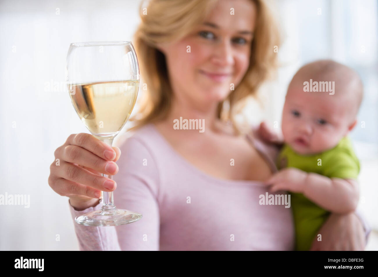 Caucasian mother with baby having glass of wine Stock Photo