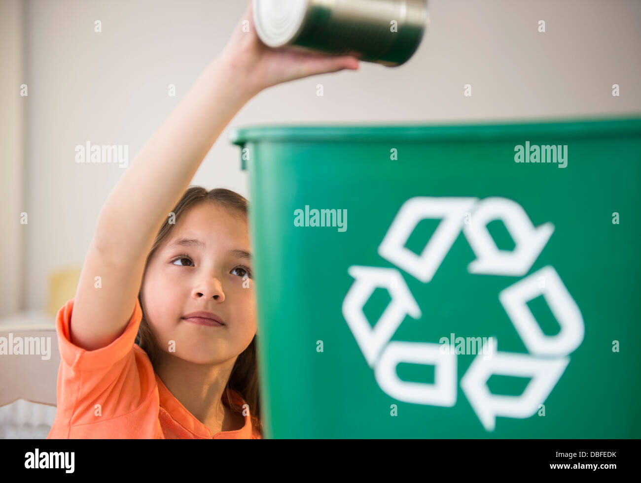 Mixed race girl recycling can Stock Photo