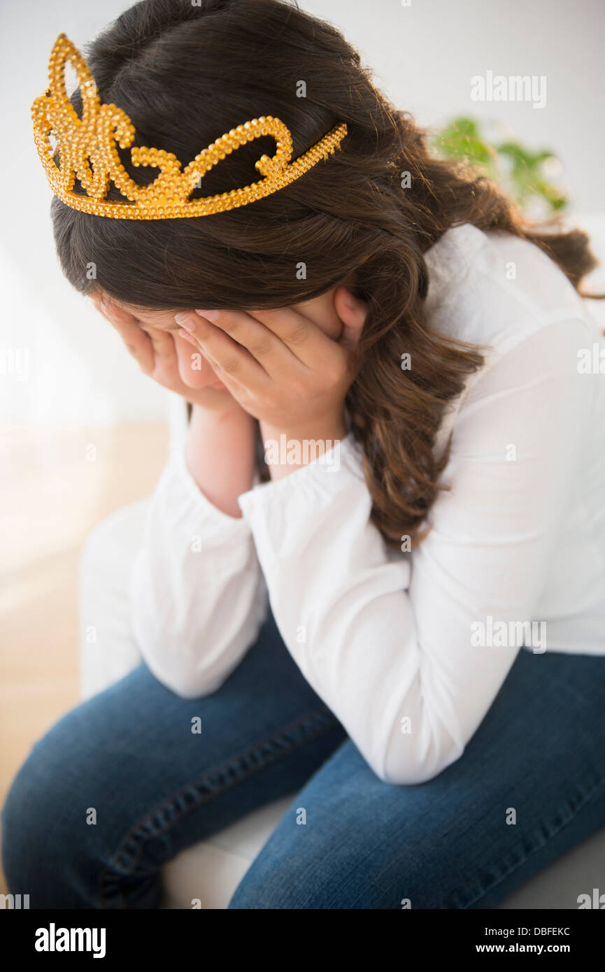 Hispanic girl in tiara crying Stock Photo