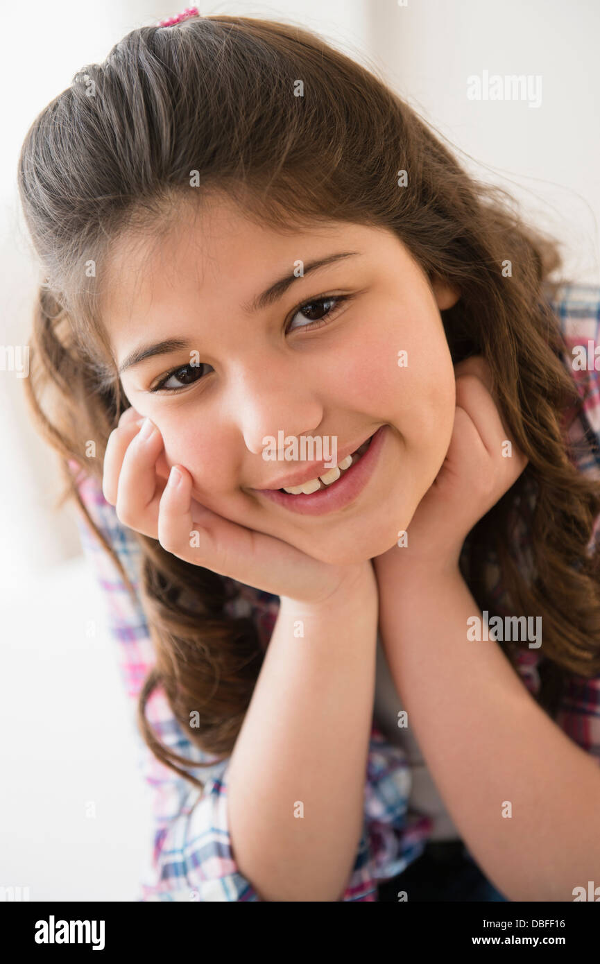 Hispanic girl smiling with chin in hands Stock Photo
