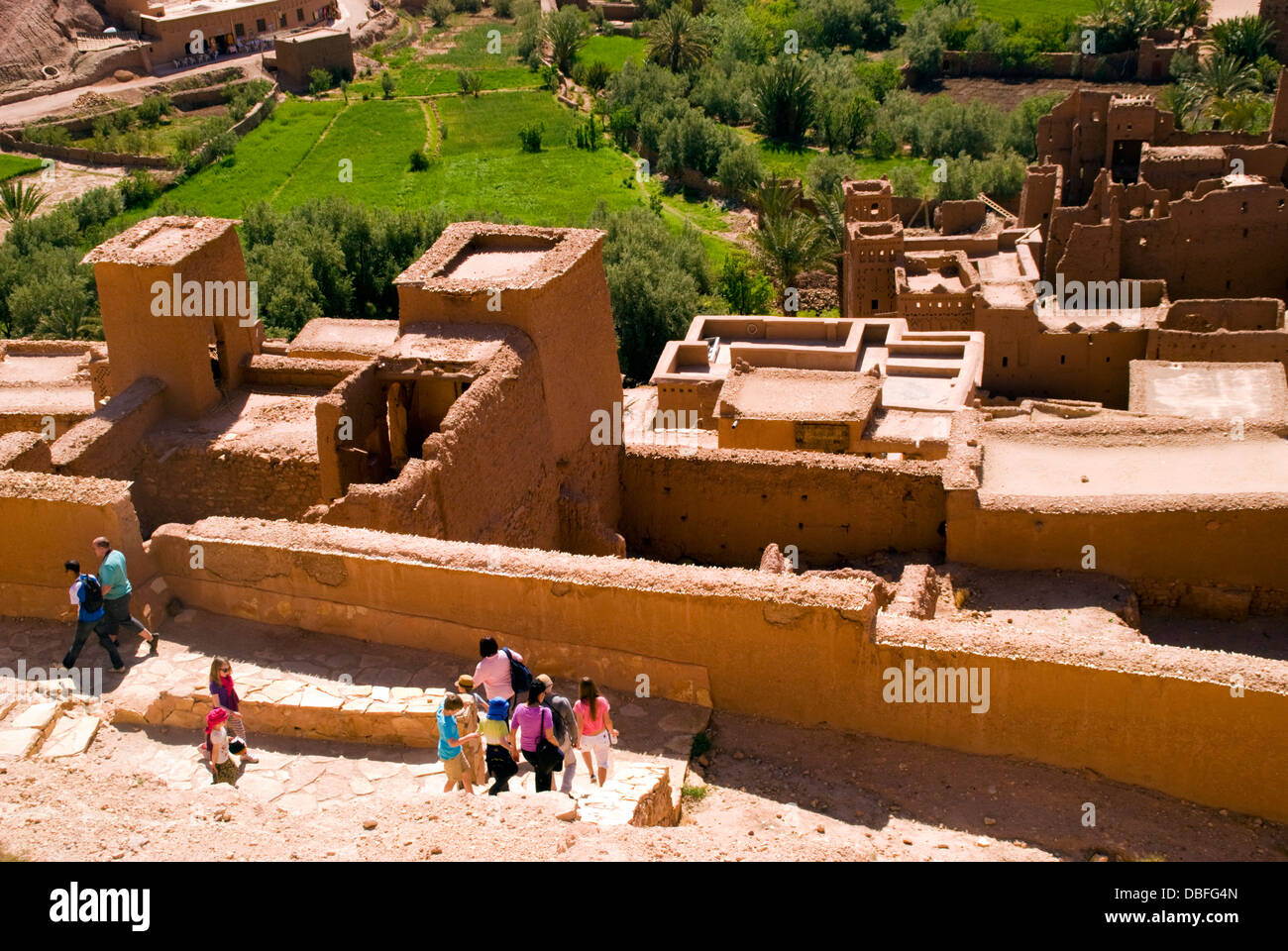 Aït Benhaddou in Berber Ath Benhadu Morocco. Tourists visit the Casbah. Most of the town's inhabitants now live in a more modern village at the other side of the river; however, eight families still live within the ksar. Stock Photo