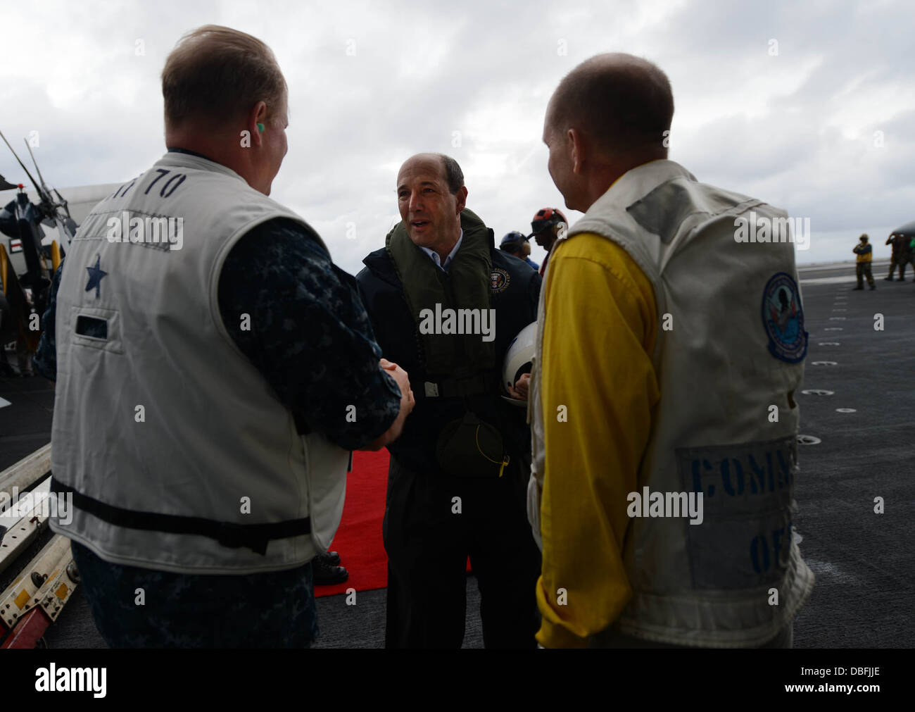 Rear Adm. Mark Montgomery, commander, Battle Force 7th Fleet, left, and Capt. Greg Fenton, right, commanding officer of the aircraft carrier USS George Washington greet U.S. Ambassador to Australia Jeffrey Bleich during a visit as a part of Talisman Saber Stock Photo