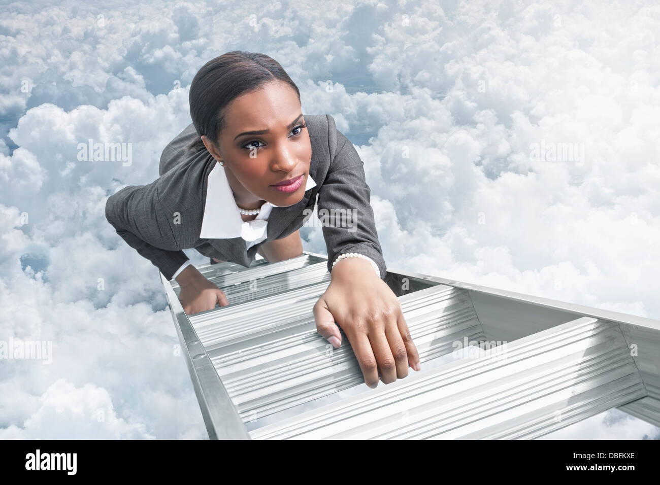 African American businesswoman climbing ladder Stock Photo
