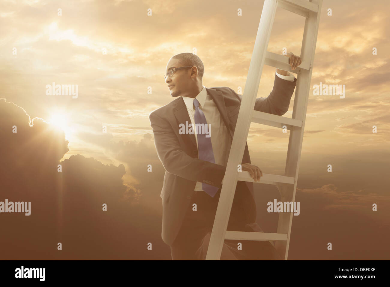 African American businessman climbing ladder Stock Photo