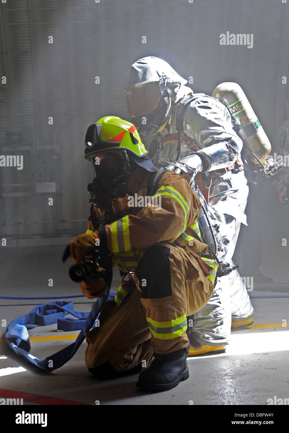 Emil Onentasei, 39th Civil Engineer Squadron firefighter crew chief, and Hakan Erdal, 39th CES firefighter, simulate extinguishing a fire during an exercise July 24, 2013, at Incirlik Air Base, Turkey. Wing-wide exercises can test any Airman’s abilities t Stock Photo