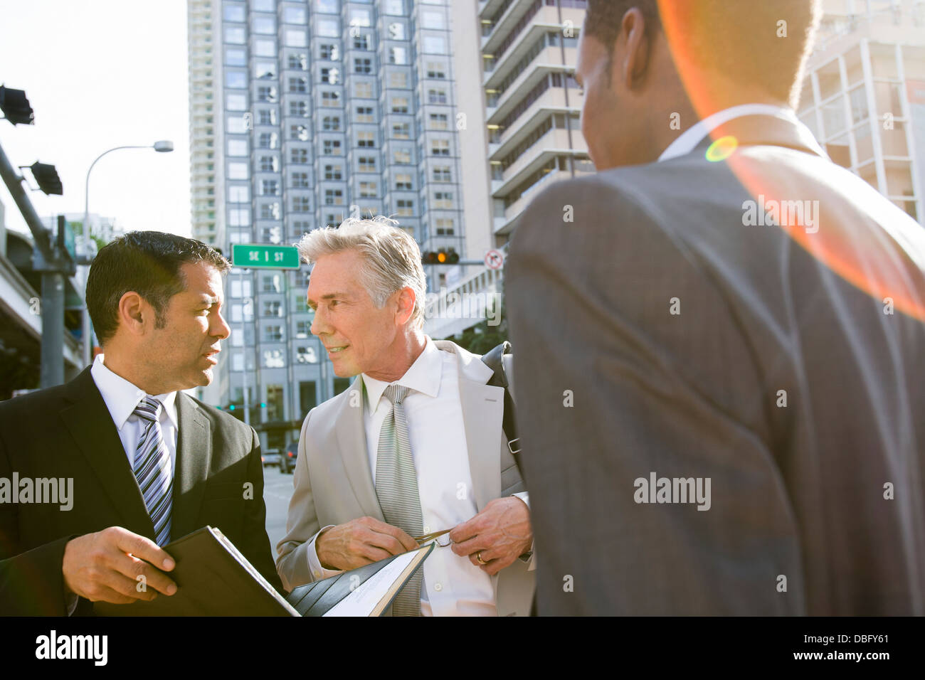 Businessmen talking on city street Stock Photo