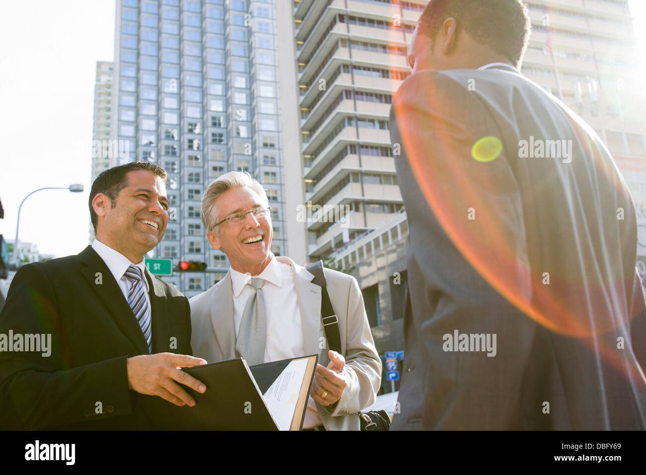 Businessmen talking on city street Stock Photo