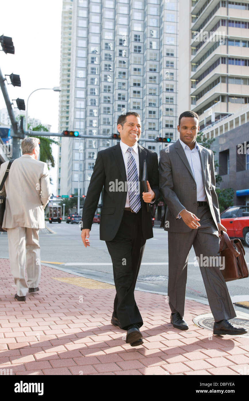 Businessmen walking together on city street Stock Photo