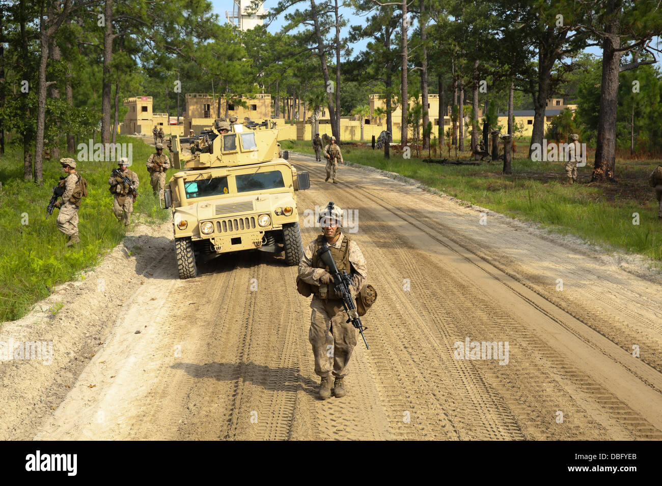 Marines with 3rd Battalion, 8th Marine Regiment, patrol the outskirts of combat town aboard Marine Corps Base Camp Lejeune, N.C. during an amphibious operation training exercise July 24, 2013. Marines and equipment were transported from the USS Wasp to On Stock Photo