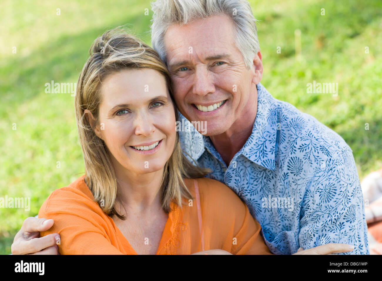 Caucasian couple relaxing in grass Stock Photo - Alamy