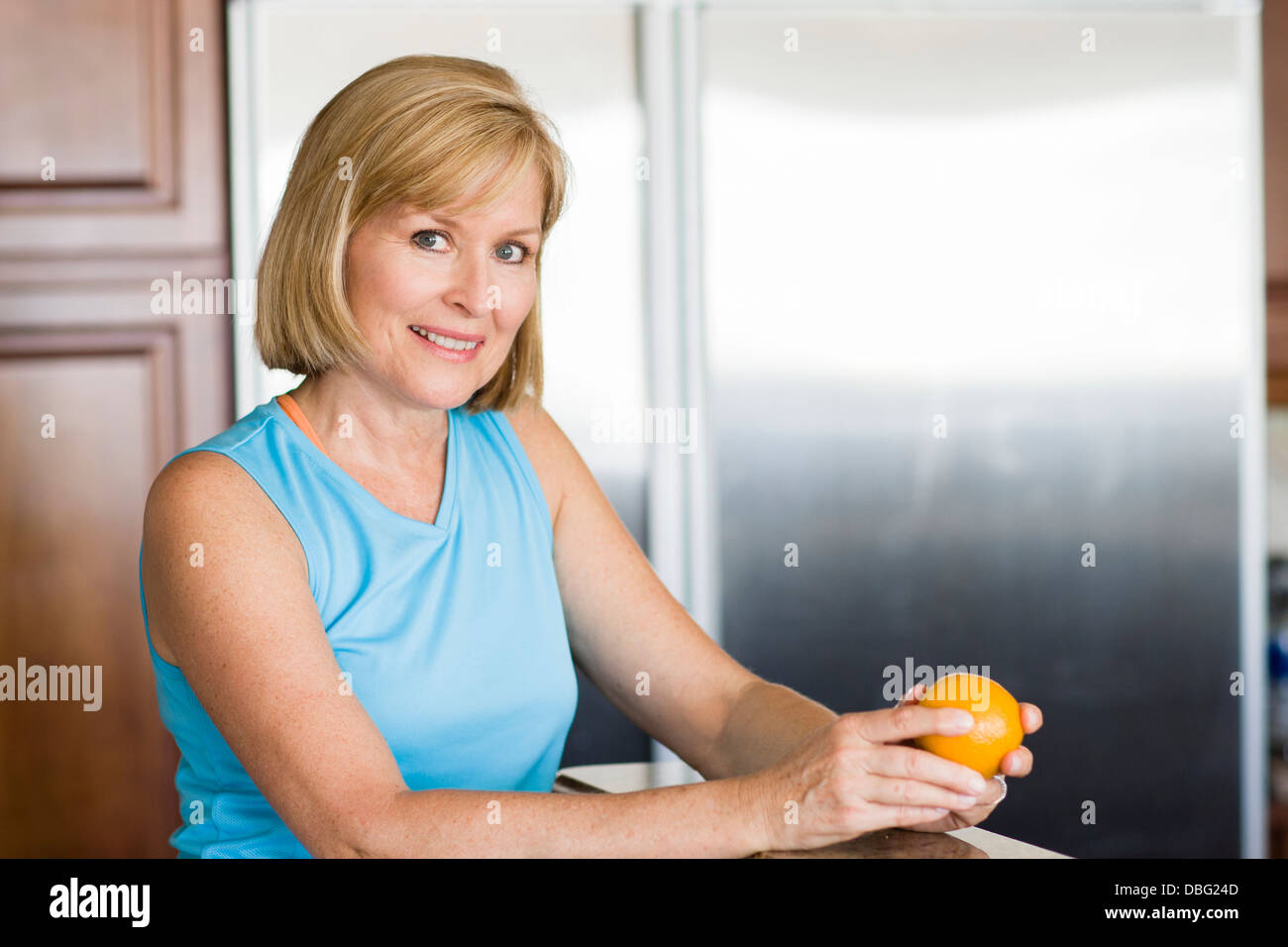 Caucasian woman peeling fruit in kitchen Stock Photo