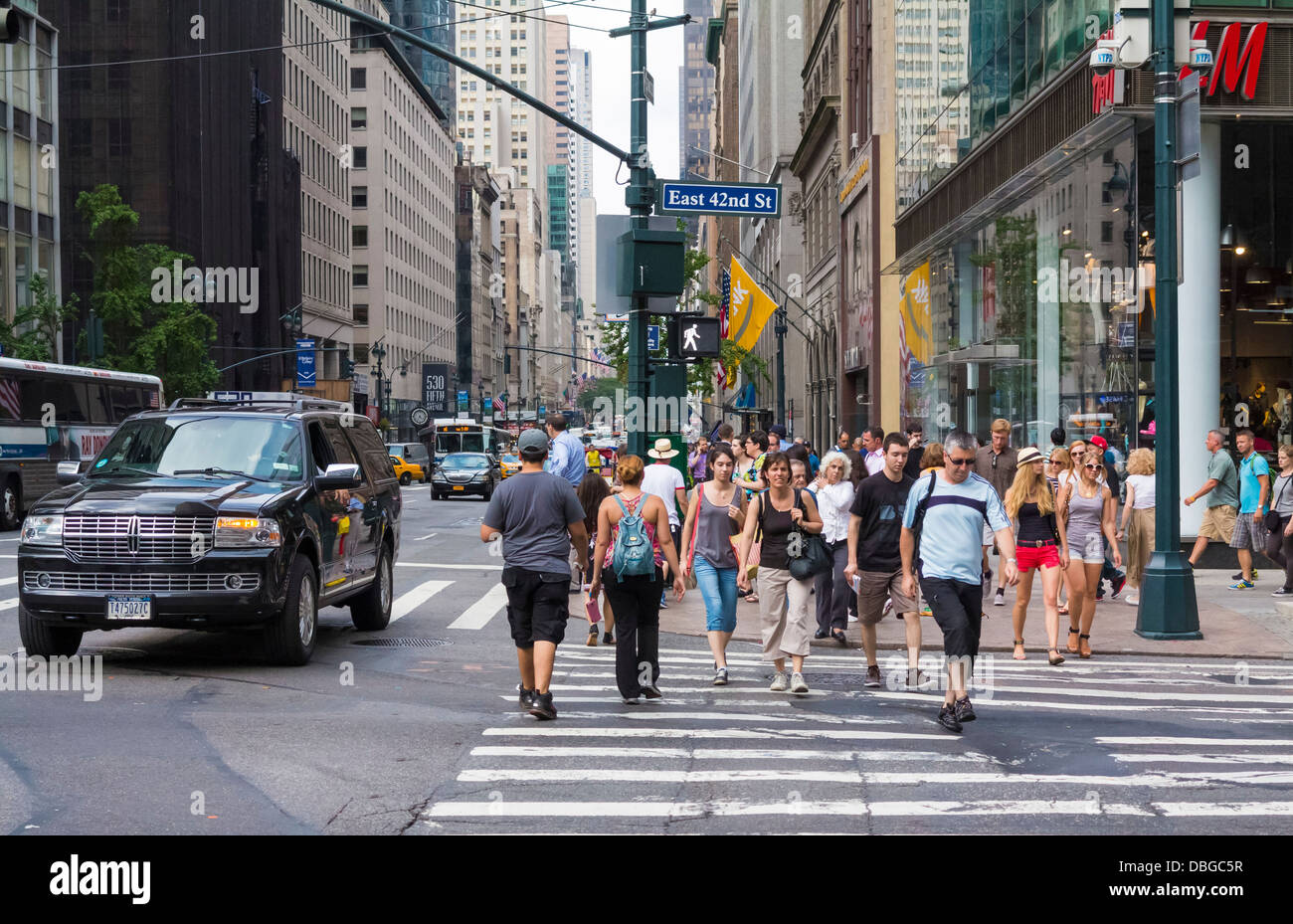 Manhattan New York street scene - people walking across a downtown crosswalk in Manhattan, New York City in summer Stock Photo