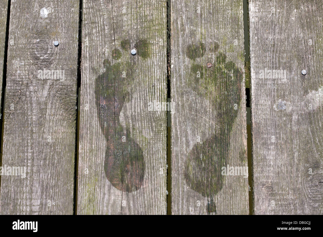 Footprints on pier on wooden boards holiday background sign Stock Photo
