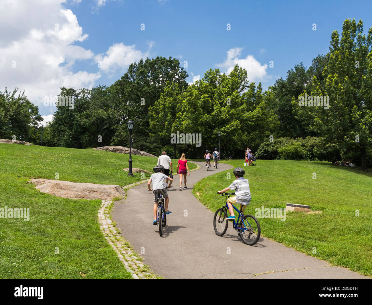 Children cycling in Central Park, NYC on a path in the summer Stock Photo