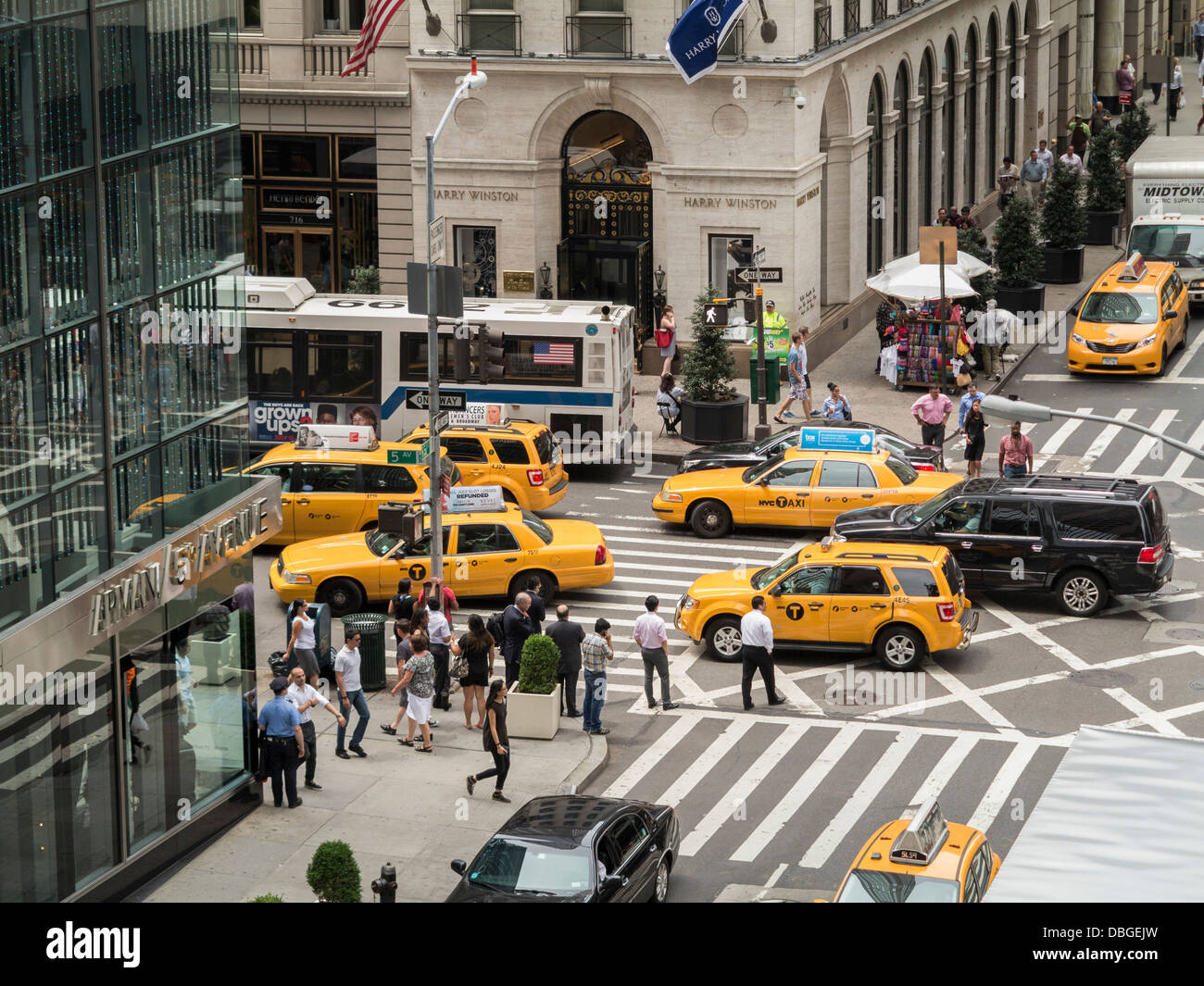 New York City street, downtown traffic cars and yellow taxi cabs on 5th Avenue and people on the sidewalks Stock Photo