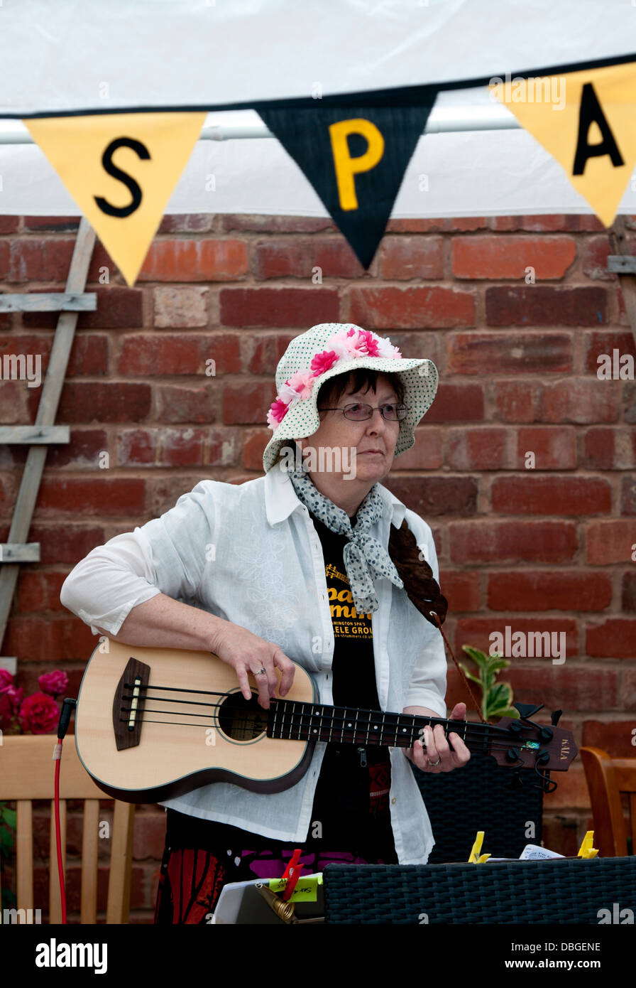 Woman playing ukulele bass. Stock Photo