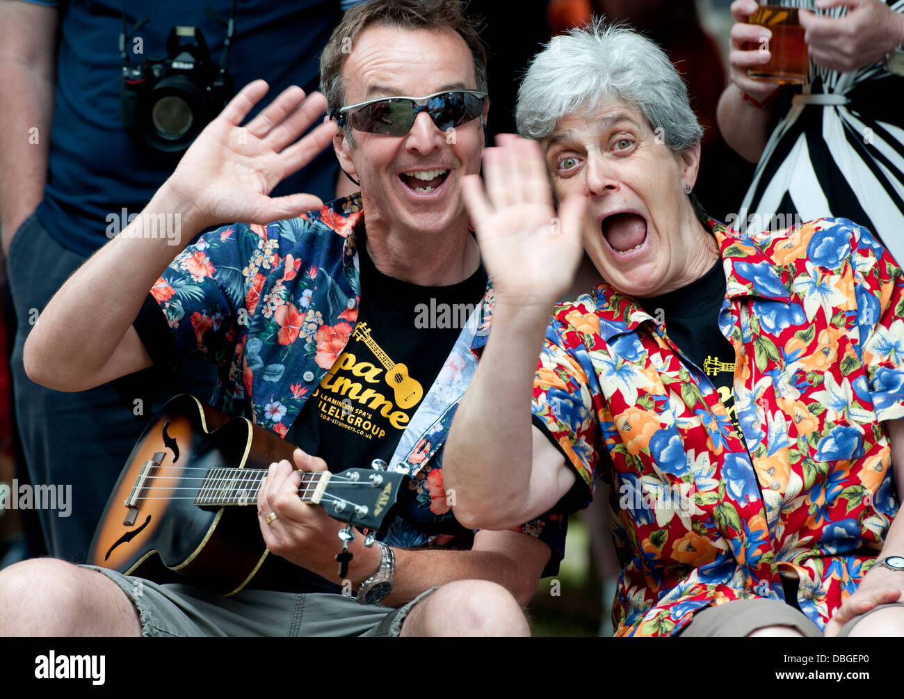 People at a ukulele festival wearing colourul shirts and waving. Stock Photo