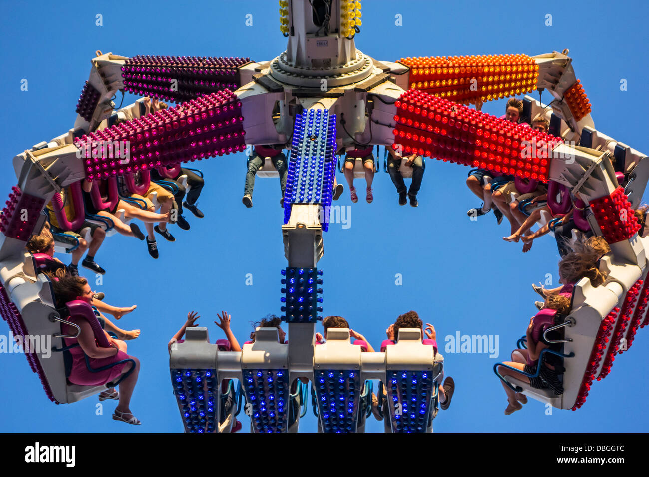 Excited thrillseekers / thrill seekers having fun on fairground attraction G Force at travelling funfair / traveling fun fair Stock Photo