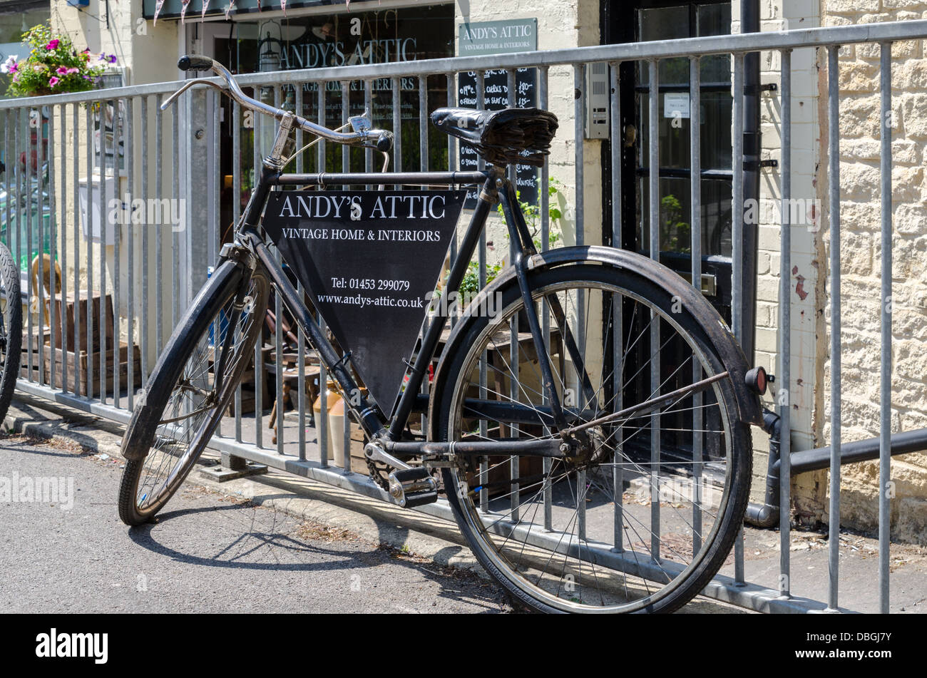 Old fashioned bicycle advertising Andy's Attic interiors shop in the Cotswold town of Nailsworth Stock Photo