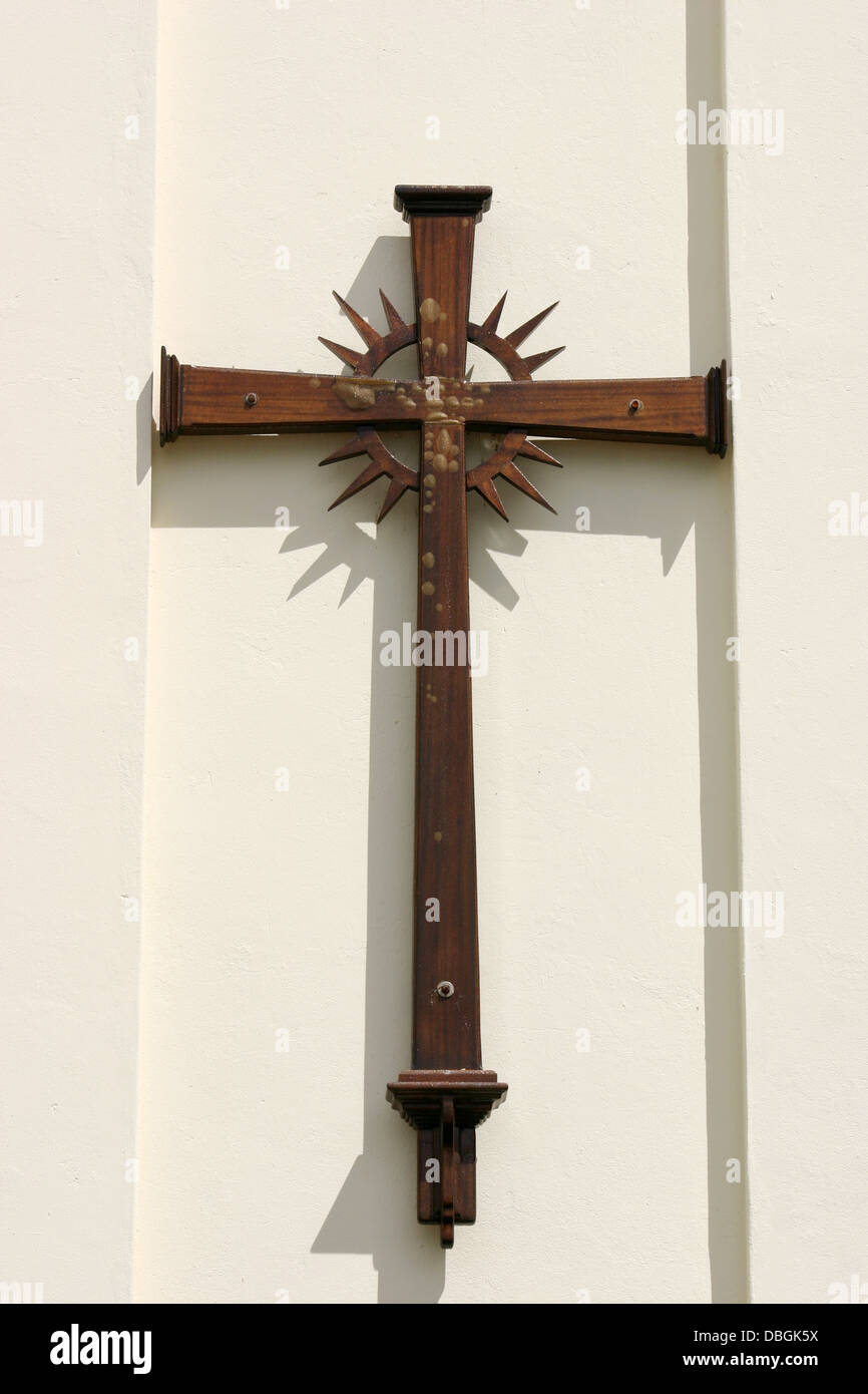 A wooden cross hanging outside of a church Stock Photo