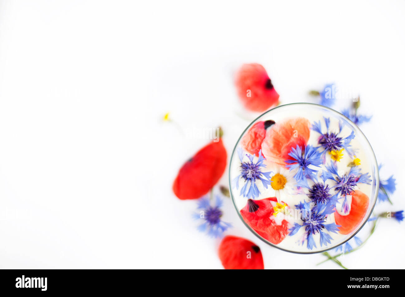 Flowers and milk in a glass from above Stock Photo