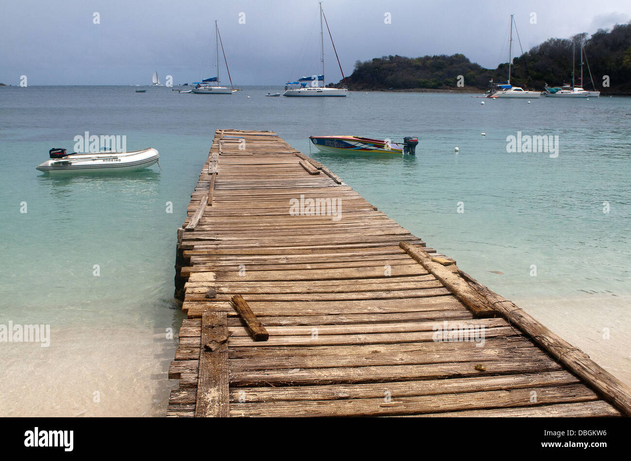 The Rickety Jetty at Salt Whistle Bay with Moored Boats and Ocean View, Mayreau, Eastern Caribbean. Stock Photo