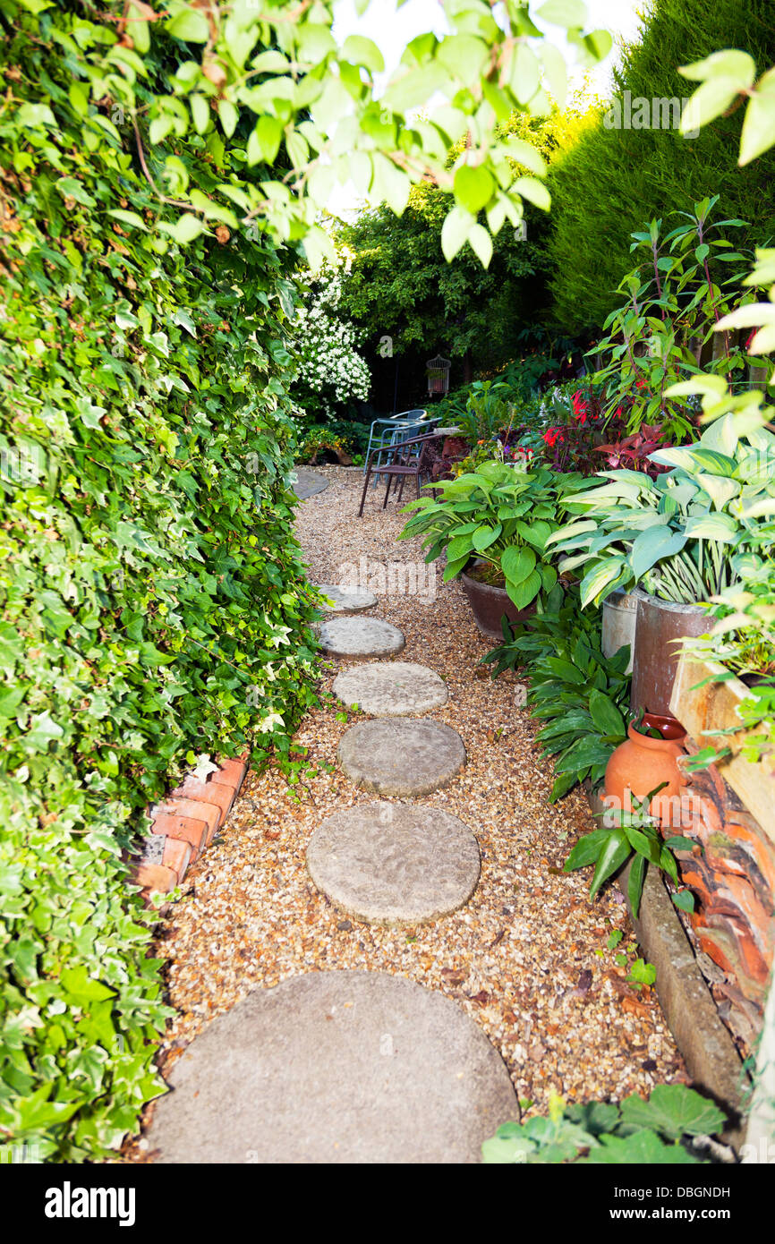 Typical English garden plants flowers and garden path stone slabs Stock Photo