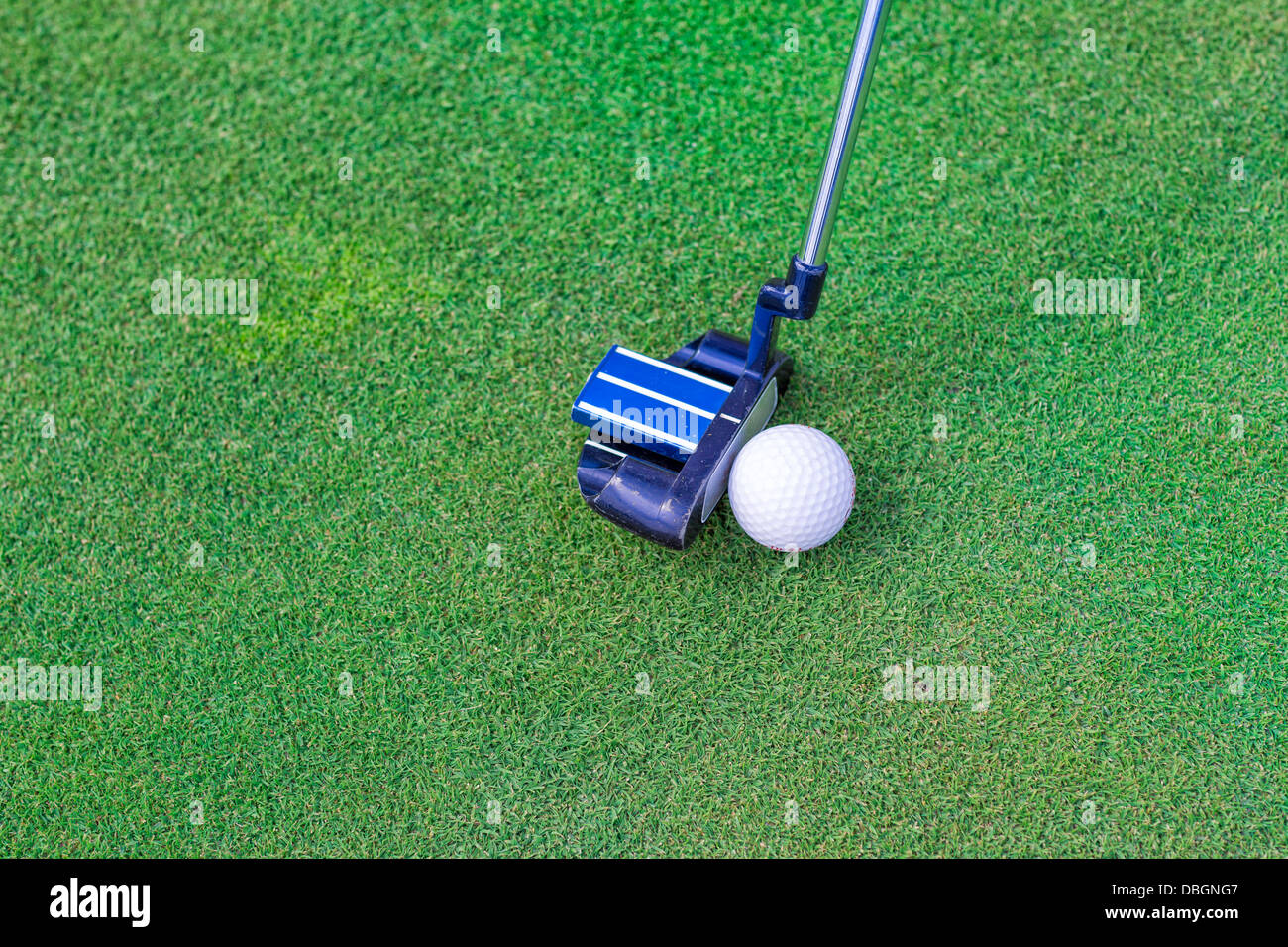 Golf stick and ball near the hole on the grass background Stock Photo