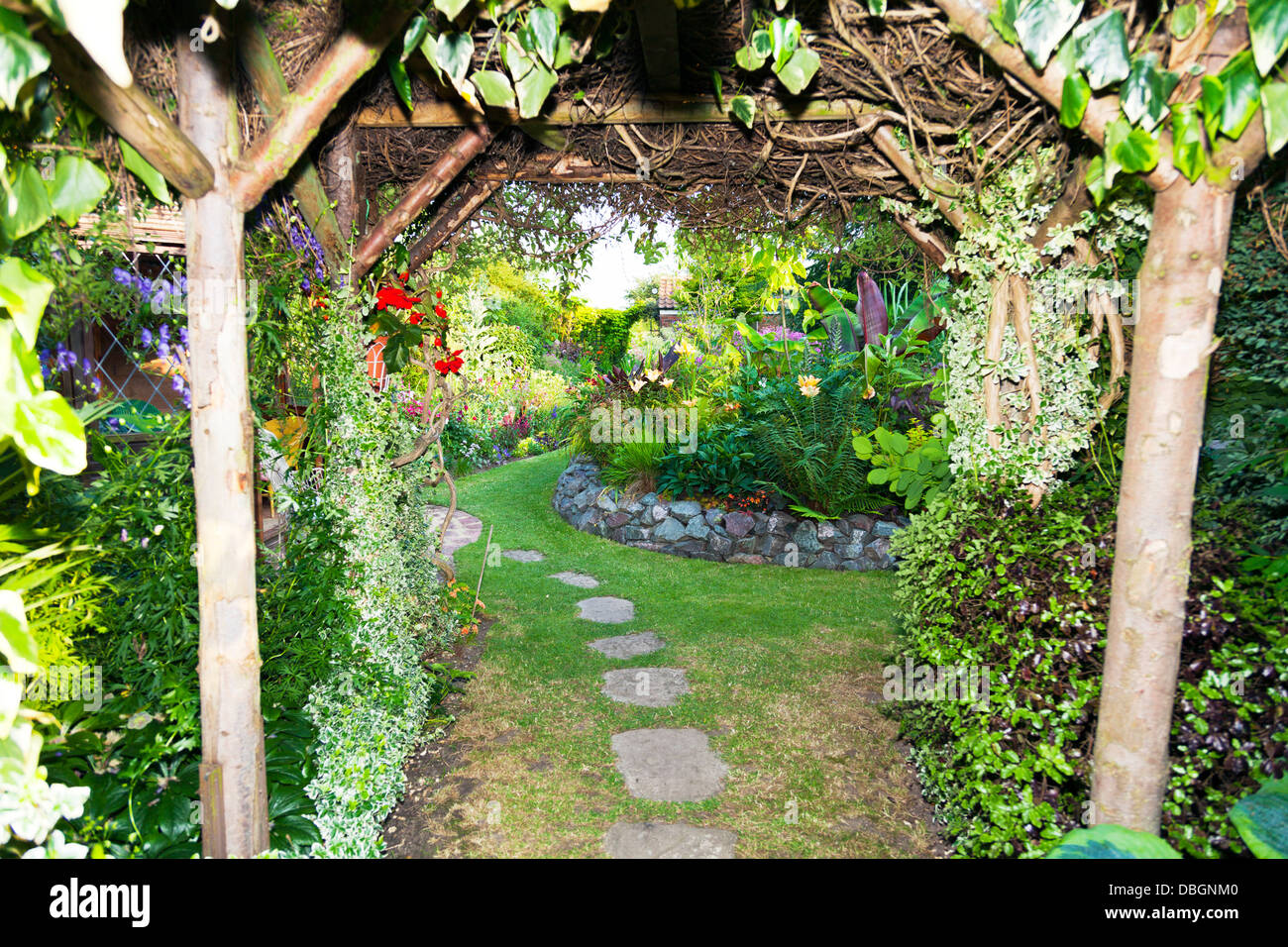 Typical English garden Arbour Arch archway Canopy leading in to garden Stock Photo