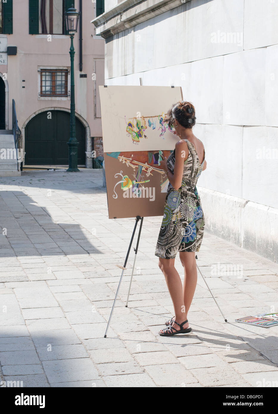 Young woman painting with an artist's easel in Venice, Italy Stock Photo