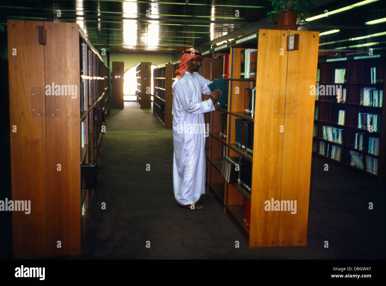 Abu Dhabi UAE Cultural Centre Man Putting Book Back On Shelf In Library